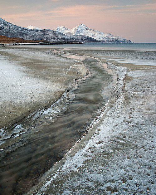 Freshwater stream on a frozen beach in Troms, Norway