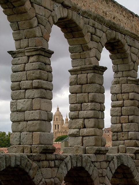 View of the cathedral through the arches of the Roman aqueduct in Segovia, Spain